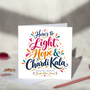 Bandi Chhor Divas greeting card reading “Here’s to Light, Hope & Chardi Kala” in colourful script lettering with hearts and gold starbursts, displayed with a white envelope