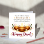 Happy Diwali greeting card with three glowing gold diyas, floral decorations and a message wishing joy, love, prosperity, health, wealth and happiness, displayed with a white envelope