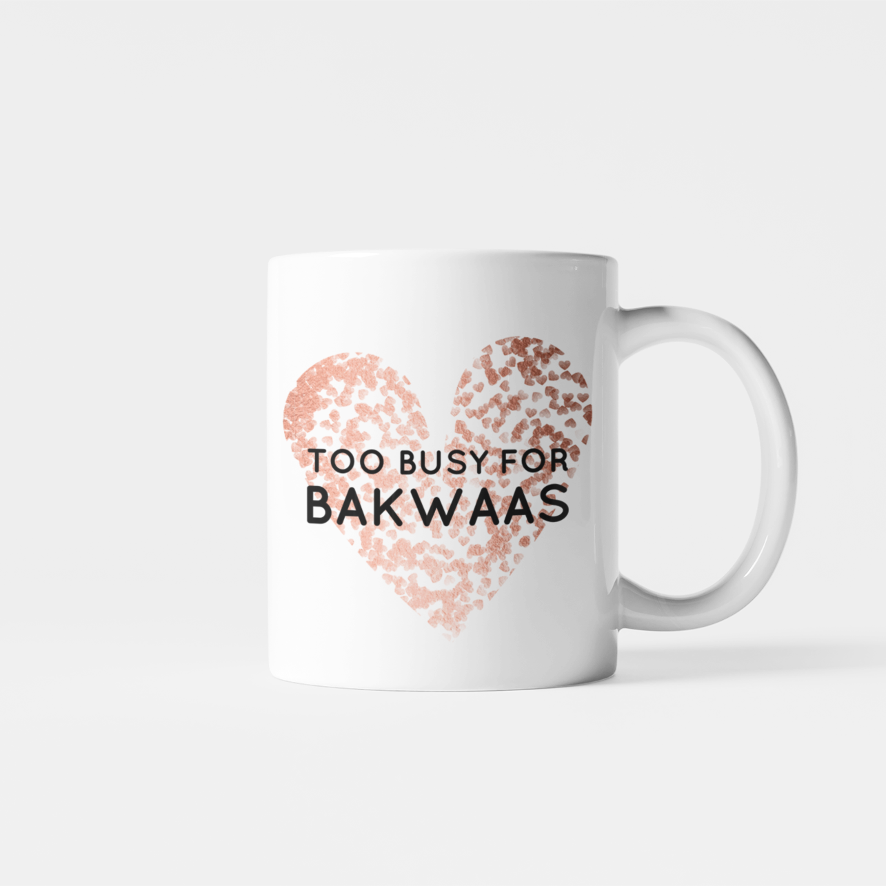 White mug with a rose gold leopard-print heart and the words “Too Busy for Bakwaas” in bold black lettering